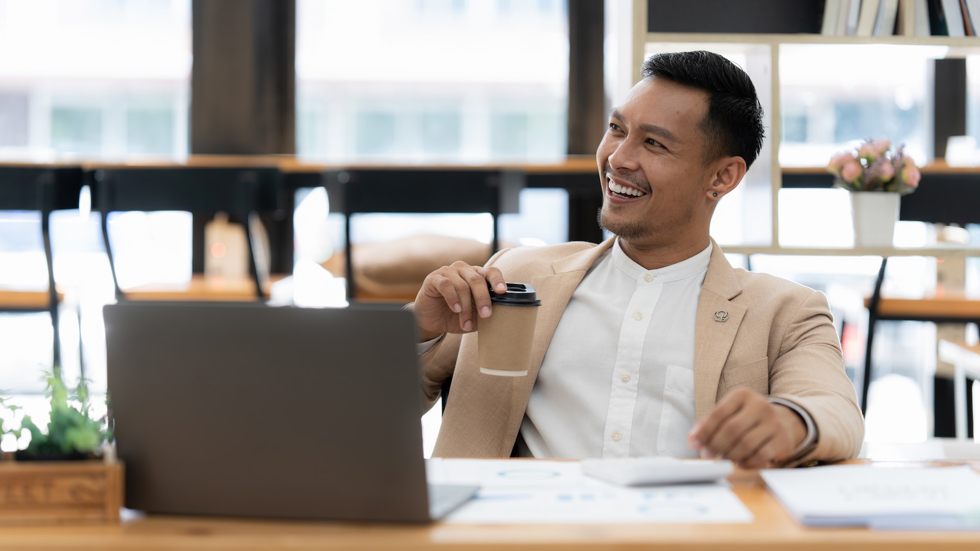 Asian Businessman smiling and working to analyze technical price graph and indicator. finance