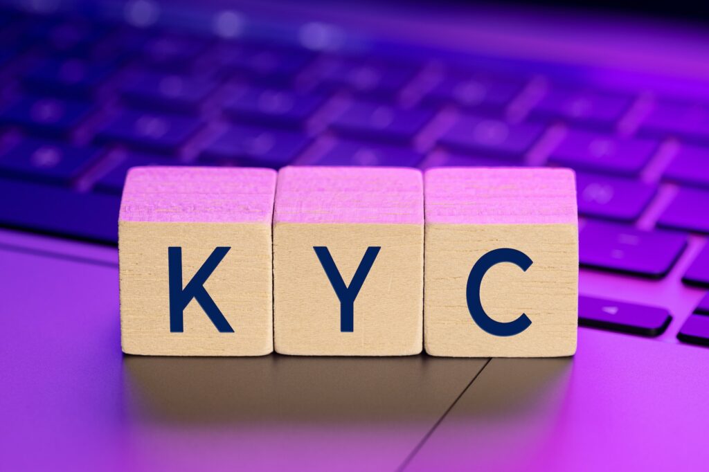 KYC word on wooden blocks on laptop with colorful lights