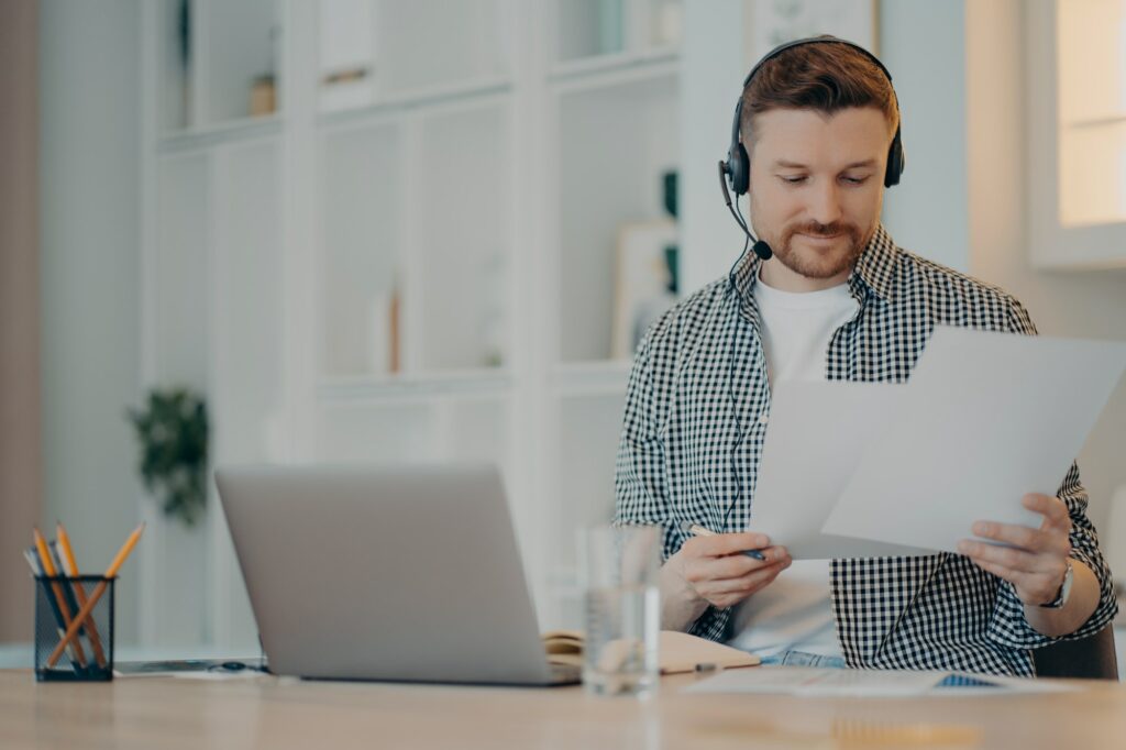 Smiling young man working with documents at home